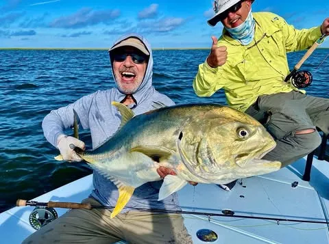 Angler holding a big jack crevalle on Capt. Jess's skiff