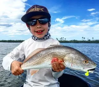 Young angler holding a redfish caught in the backcountry