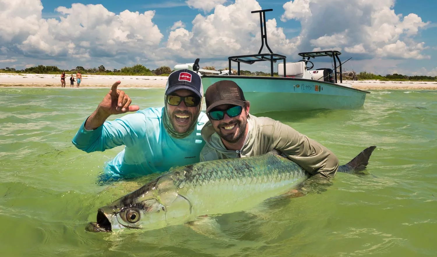 Capt. Jess and a client in the water with a big tarpon